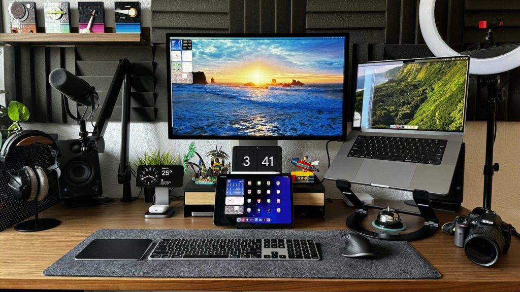 Radni sto sa monitorom, laptopom na stalku, tabletom, mikrofonom i slušalicama