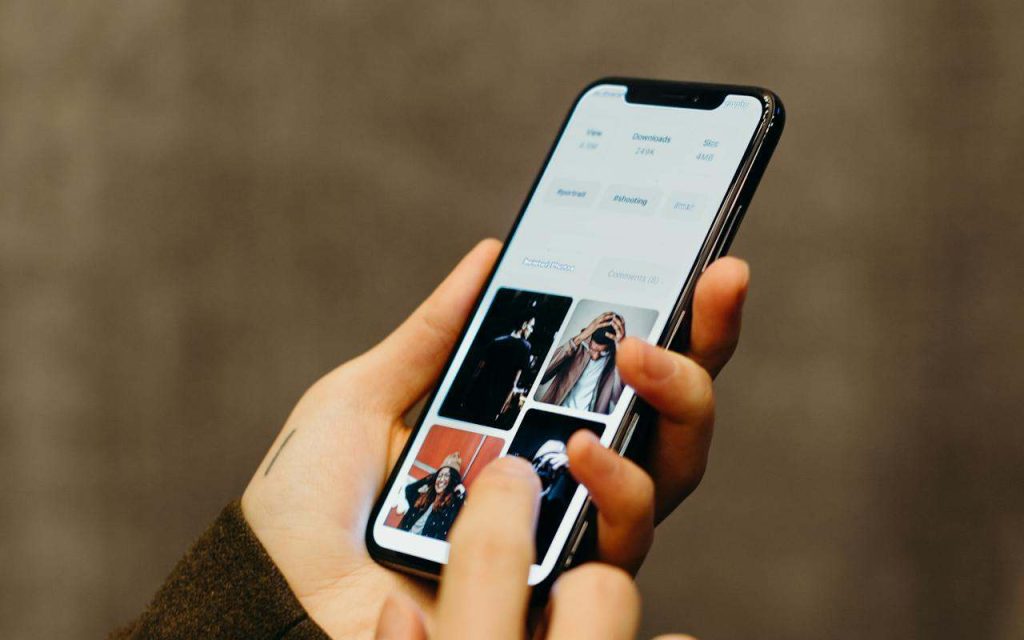 Osoba koristi telefon na čijem ekranu se vidi nekoliko slika.